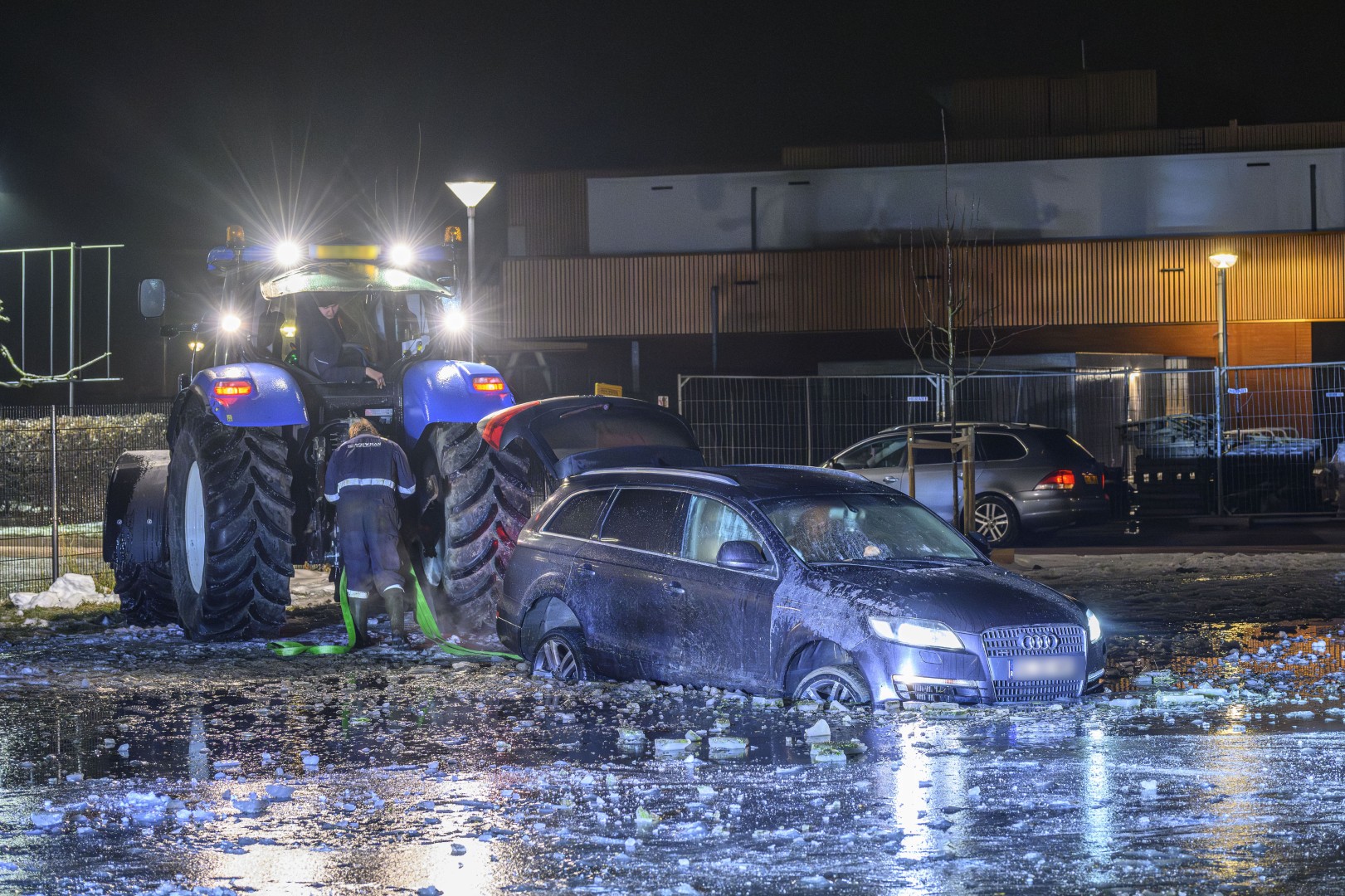 Auto zakt door ijs en komt vast te staan in diepe plas
