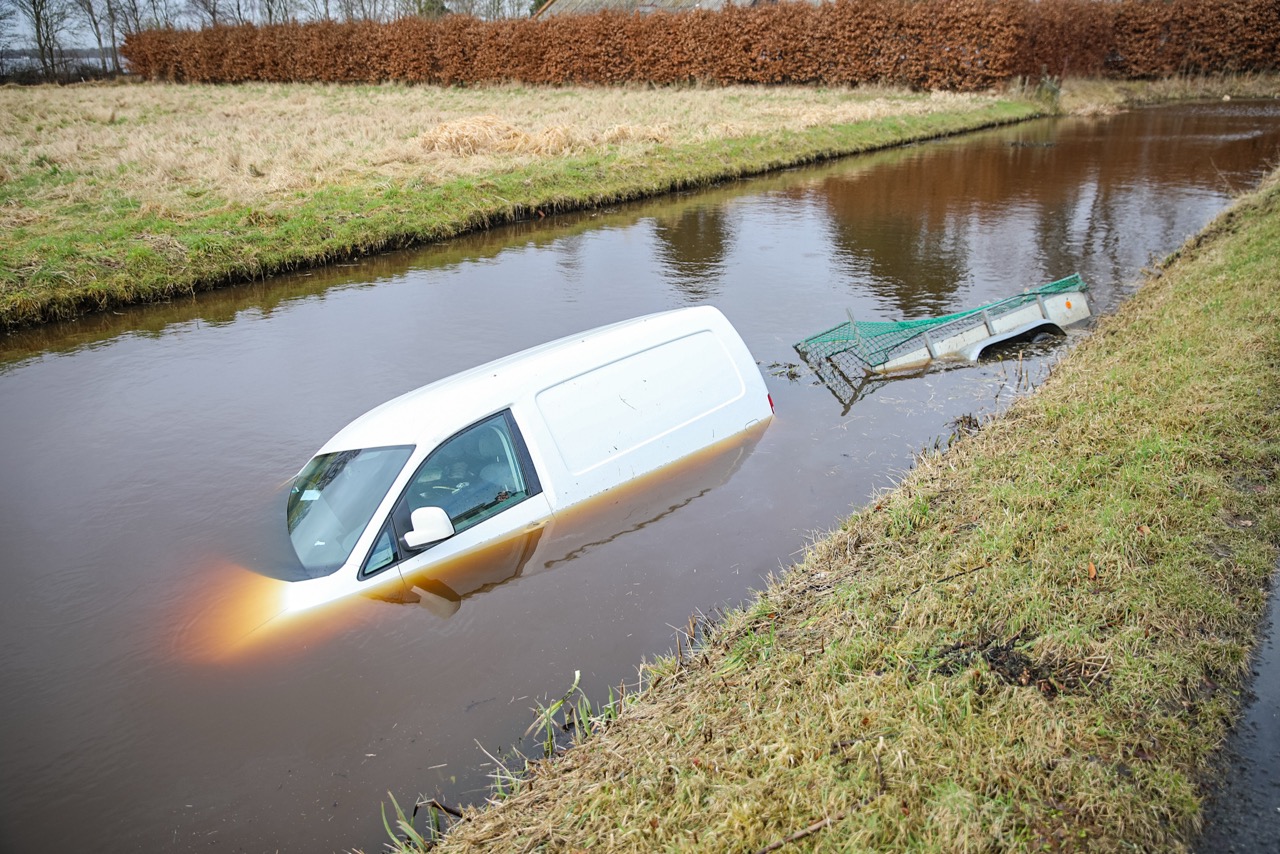 Voertuig met aanhanger belandt in kanaal
