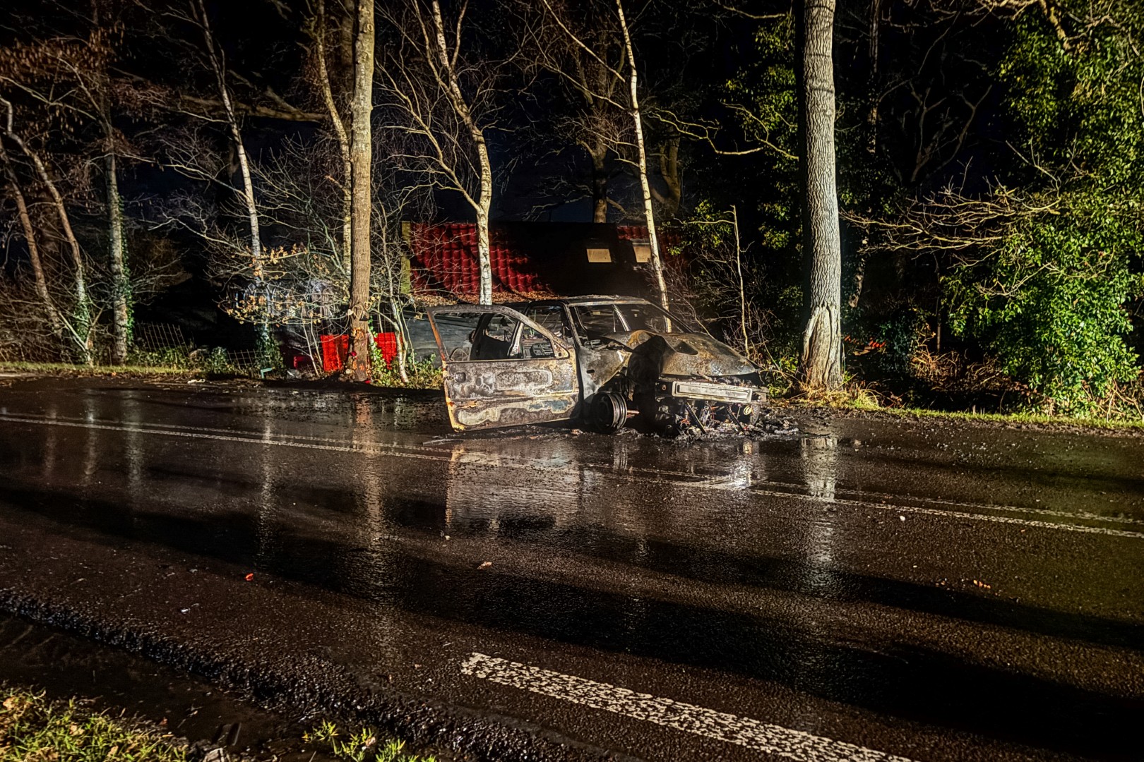Auto vliegt in brand na botsing met boom, bestuurder naar ziekenhuis