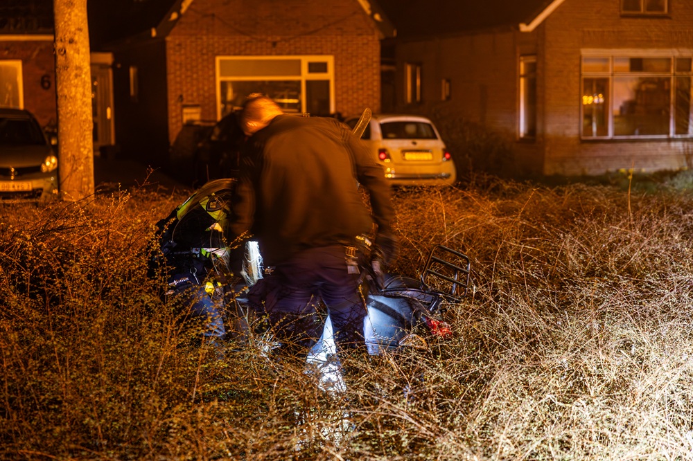Scooterrijder mist kruising en belandt in struiken