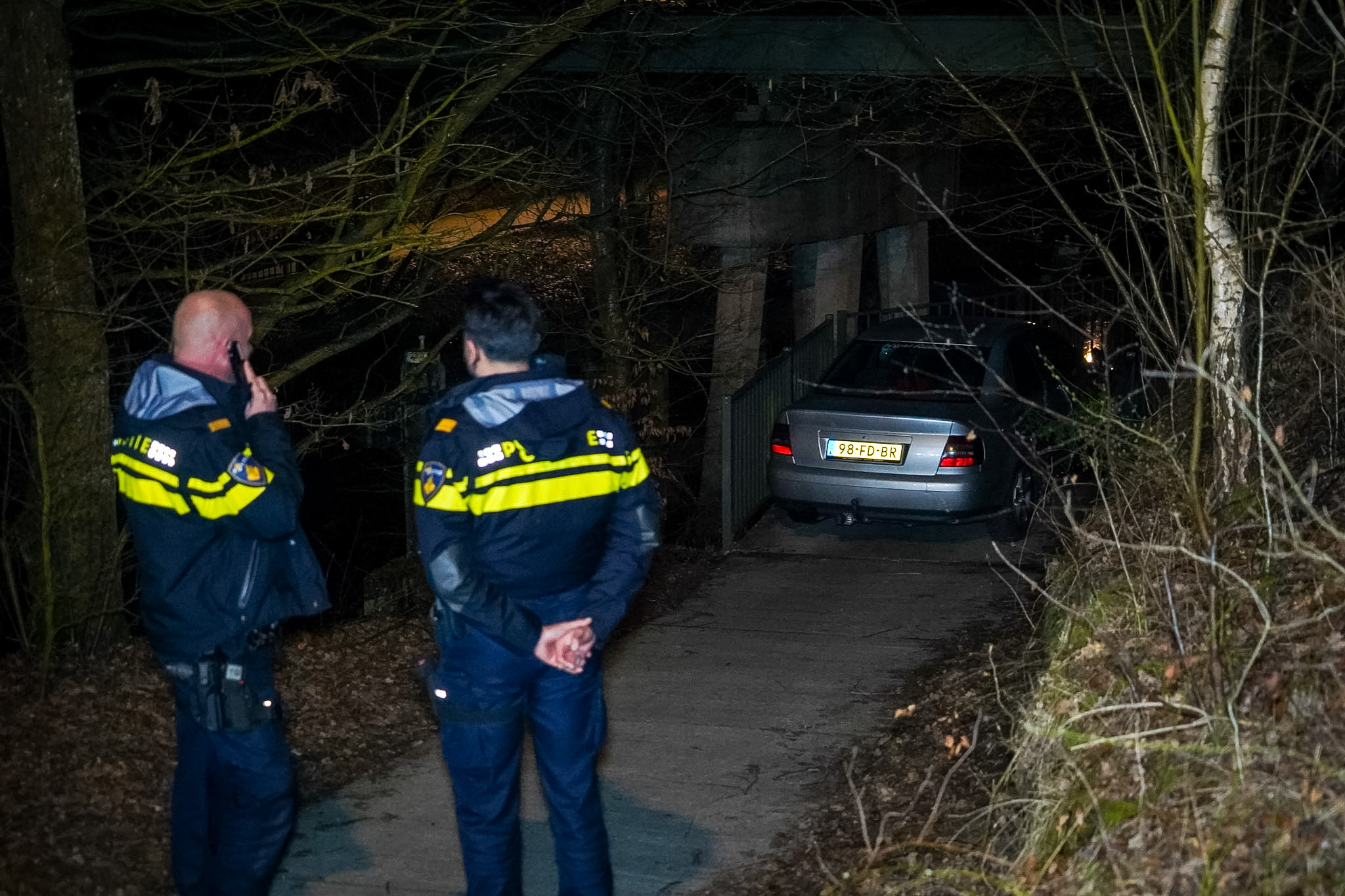 Auto rijdt zich klem op fietspad onder spoorbrug