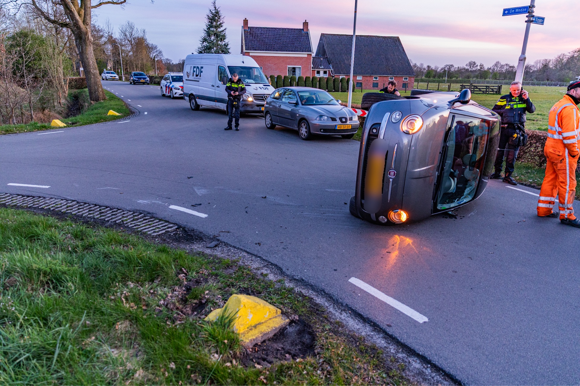 Automobiliste belandt met auto op zijkant na botsing met betonblok