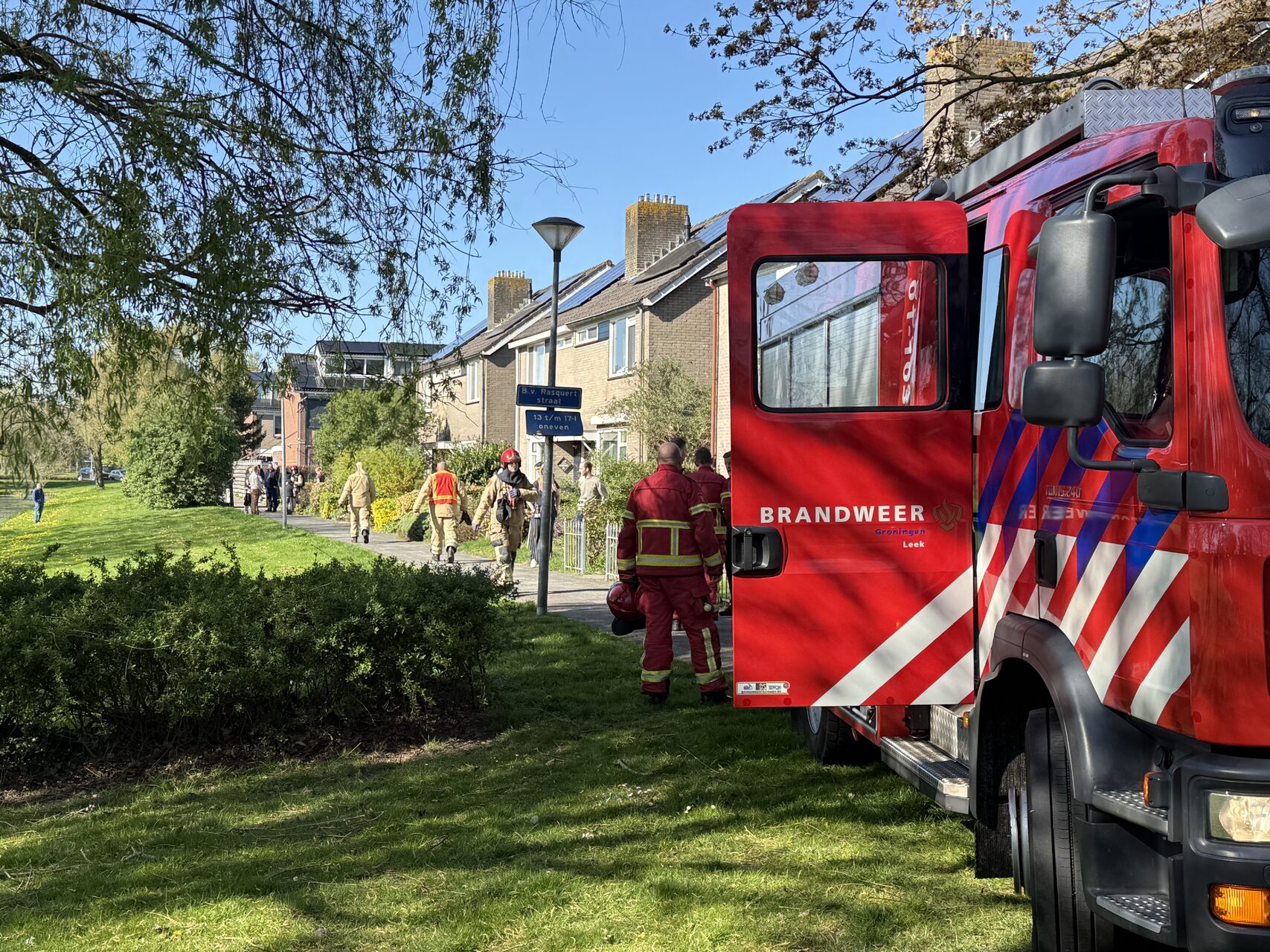 Buurtbewoner blust brand achter woning, bewoner ademt rook in