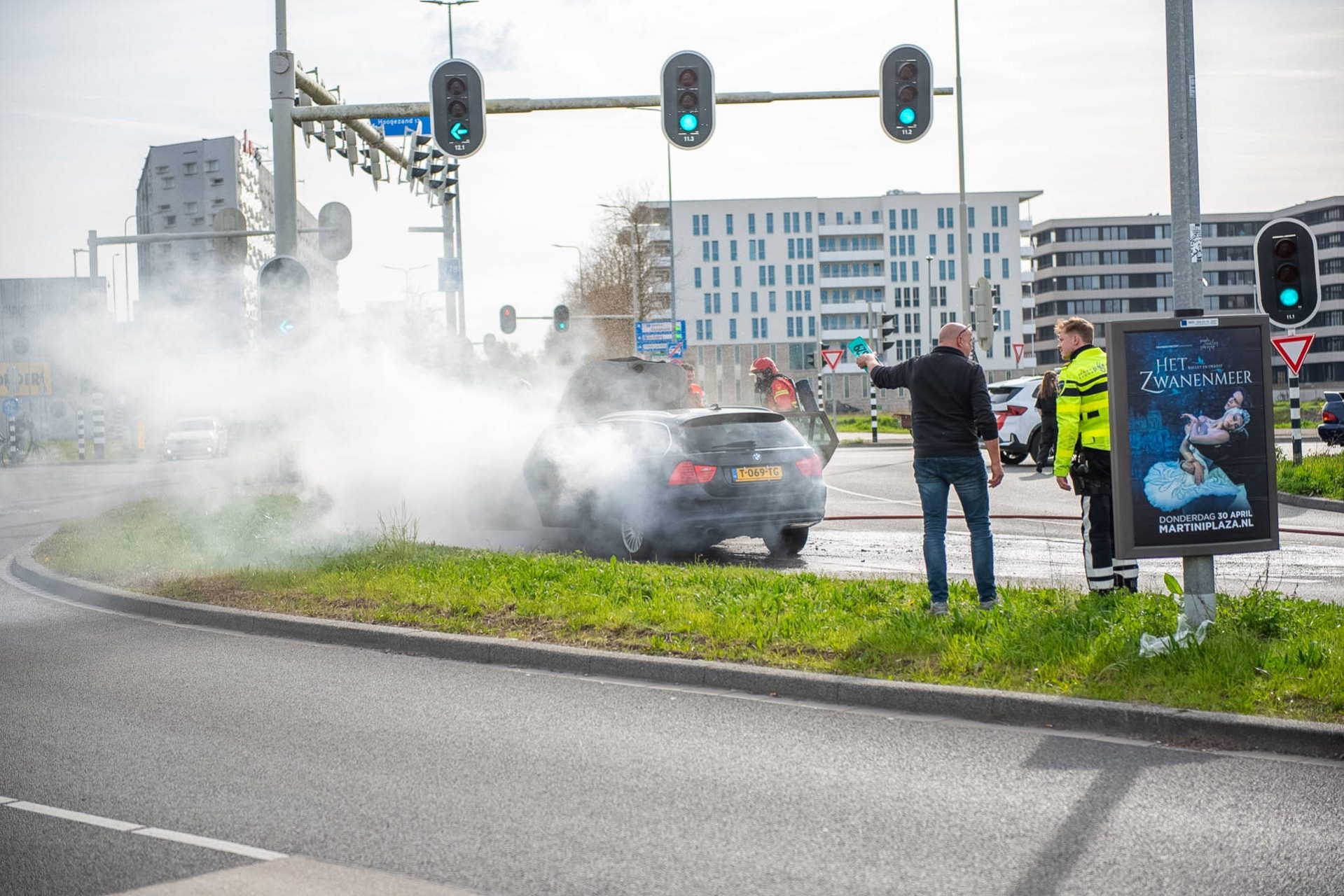 Auto vliegt in brand voor stoplicht