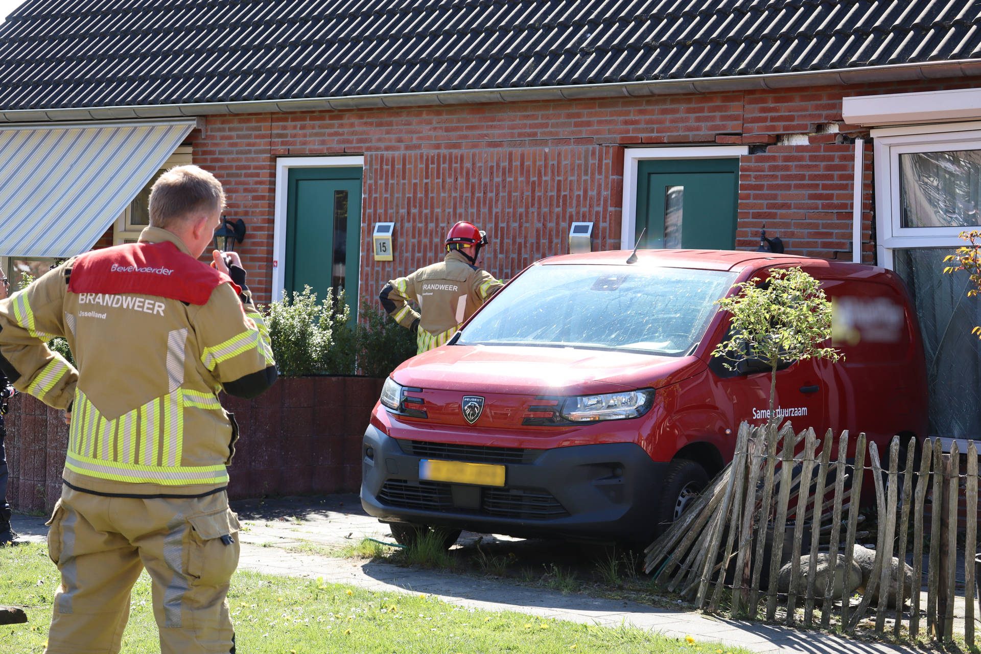 Bestelbus botst tegen woninggevel, bestuurder naar ziekenhuis