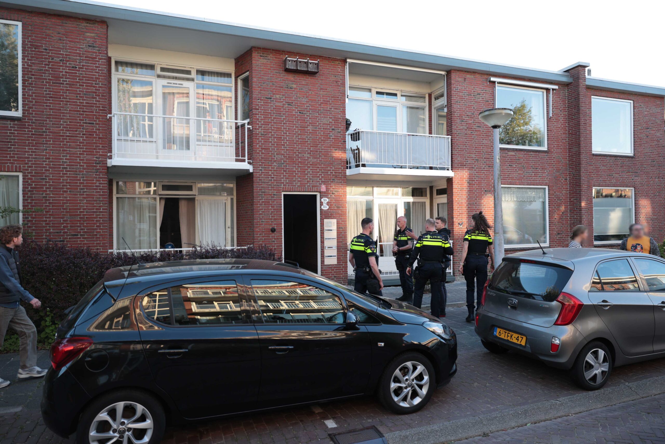 Bewoner lichtgewond bij brandende tuinset achter flatwoning