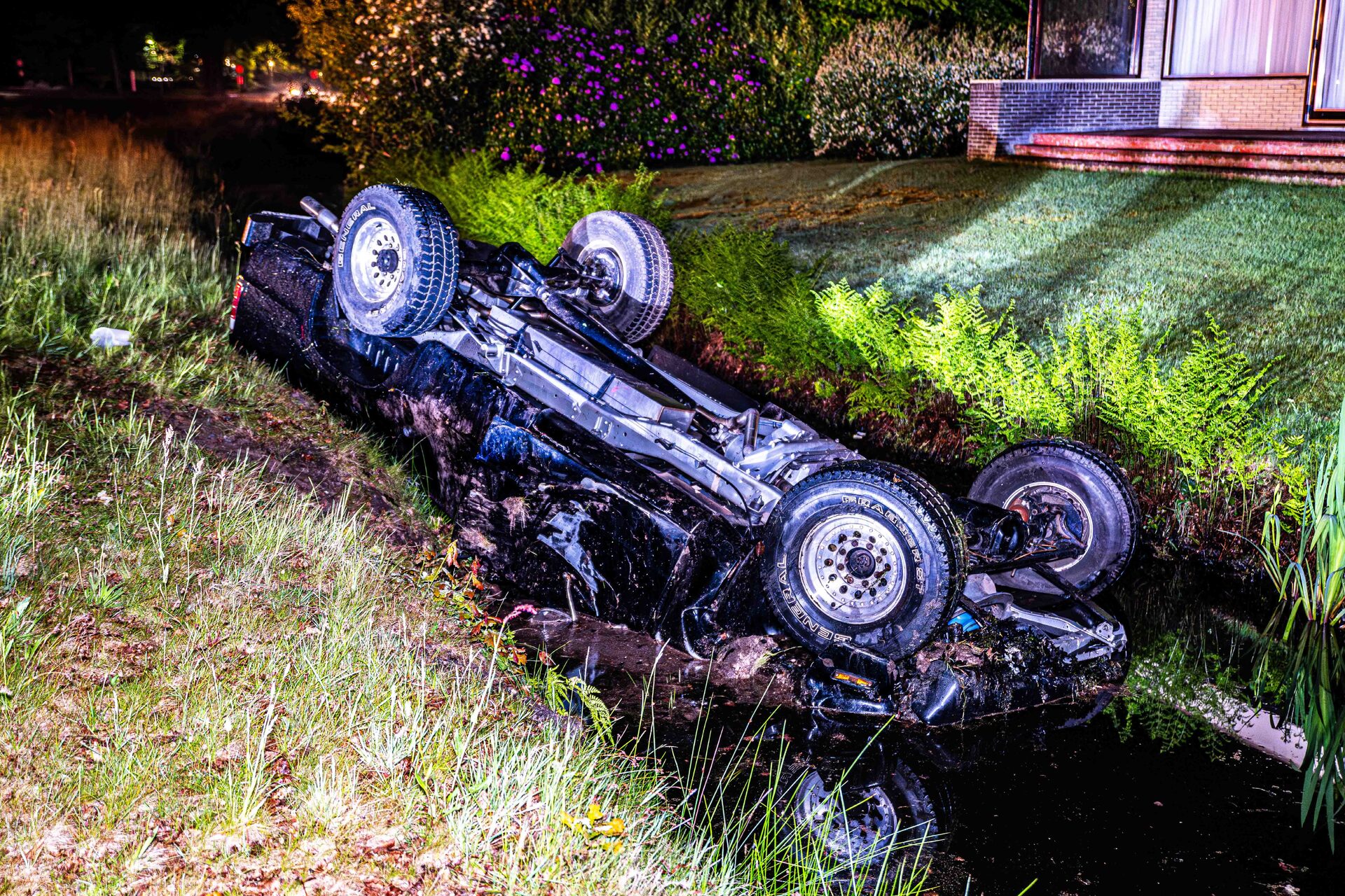 Pick-up op z’n kop in sloot, twee inzittenden gewond