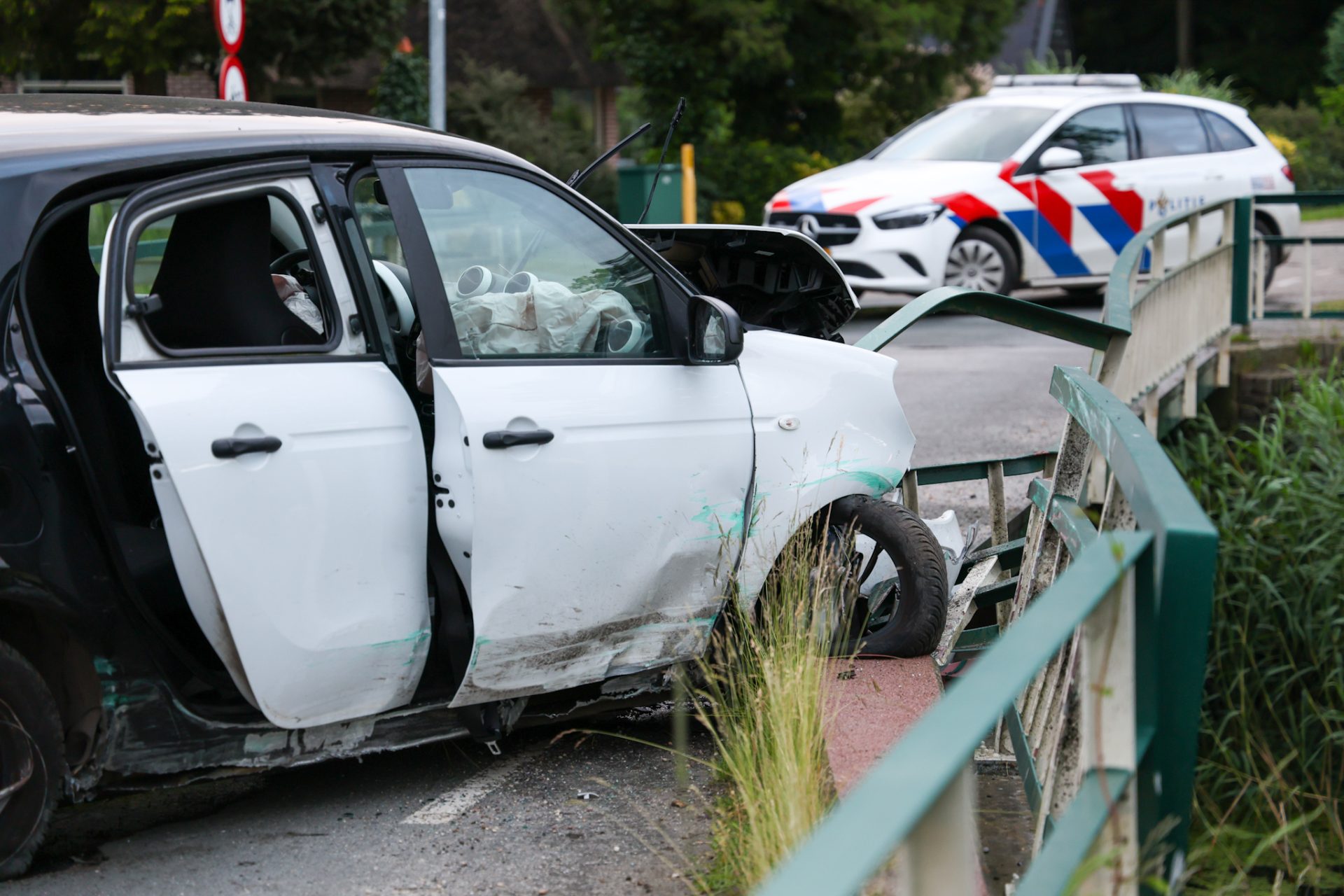 Auto crasht tegen reling van brug