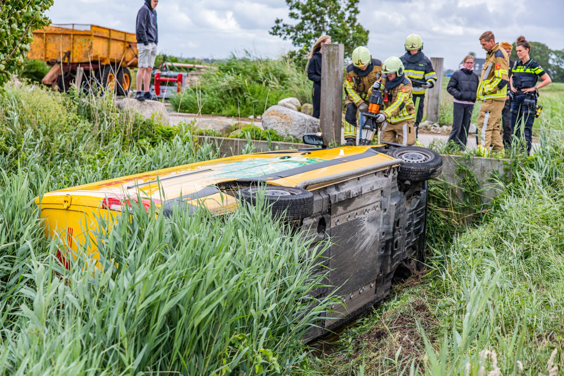 Pakketbezorger belandt op z’n zijkant in sloot