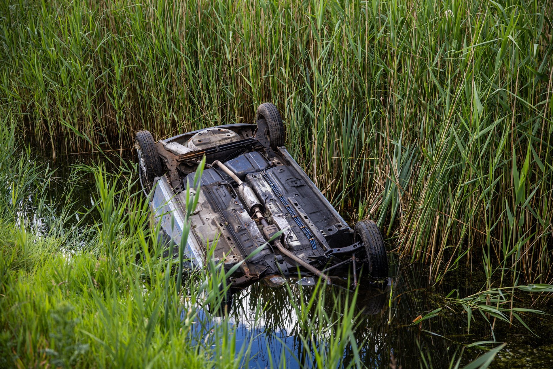 Auto op z’n kop in sloot, bestuurder met schrik vrij