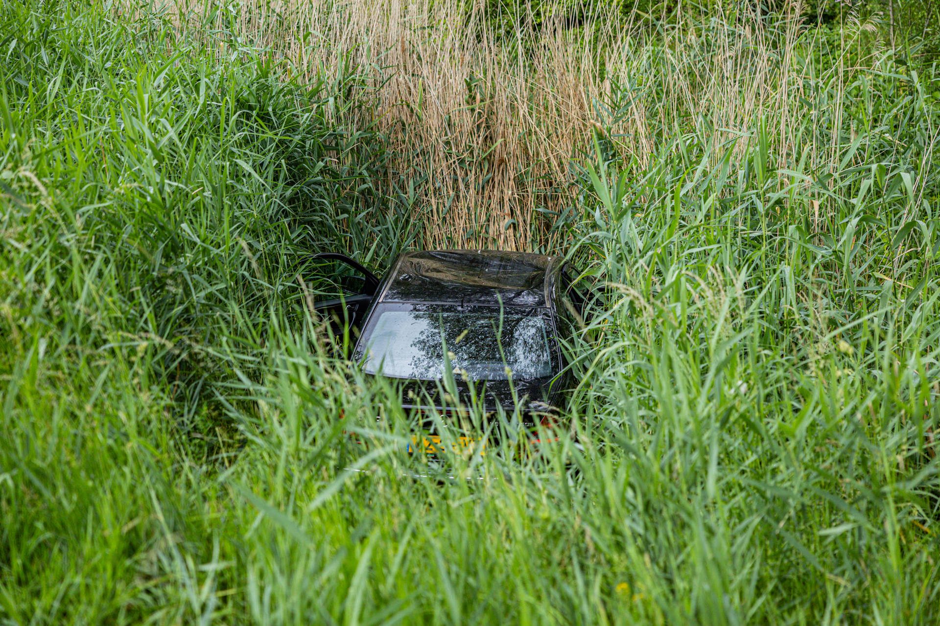 Automobilist belandt na botsing met lantaarnpaal in sloot