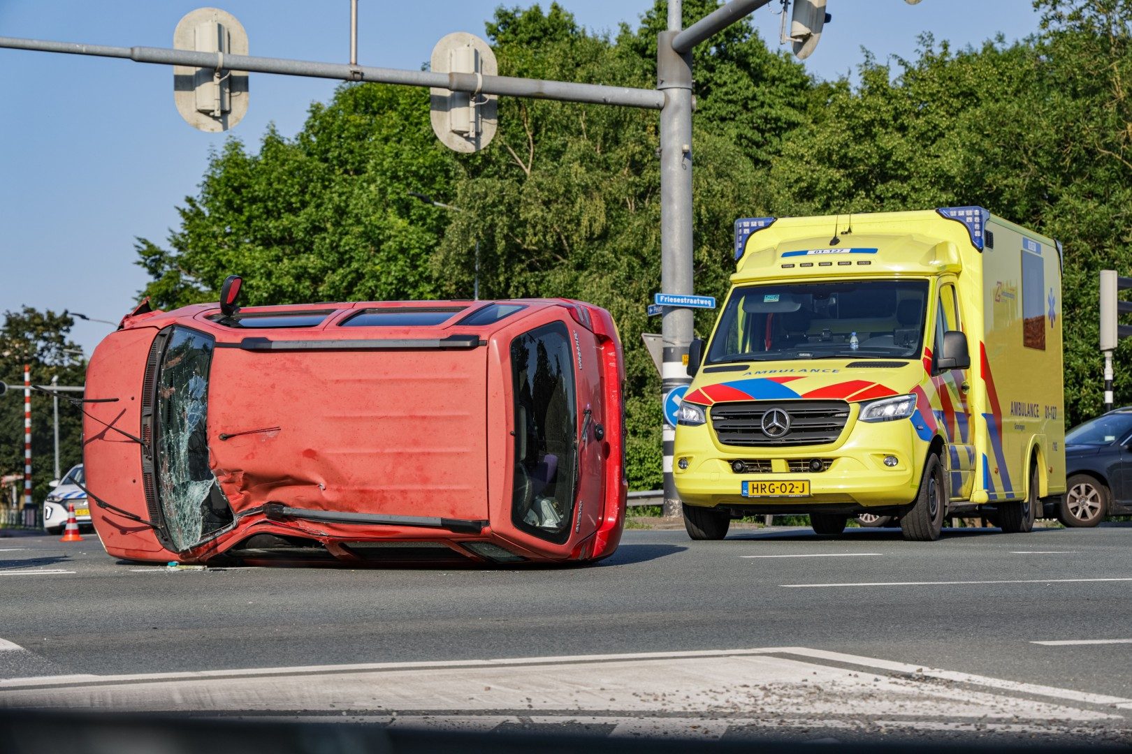 Auto op zijkant na aanrijding met drie voertuigen
