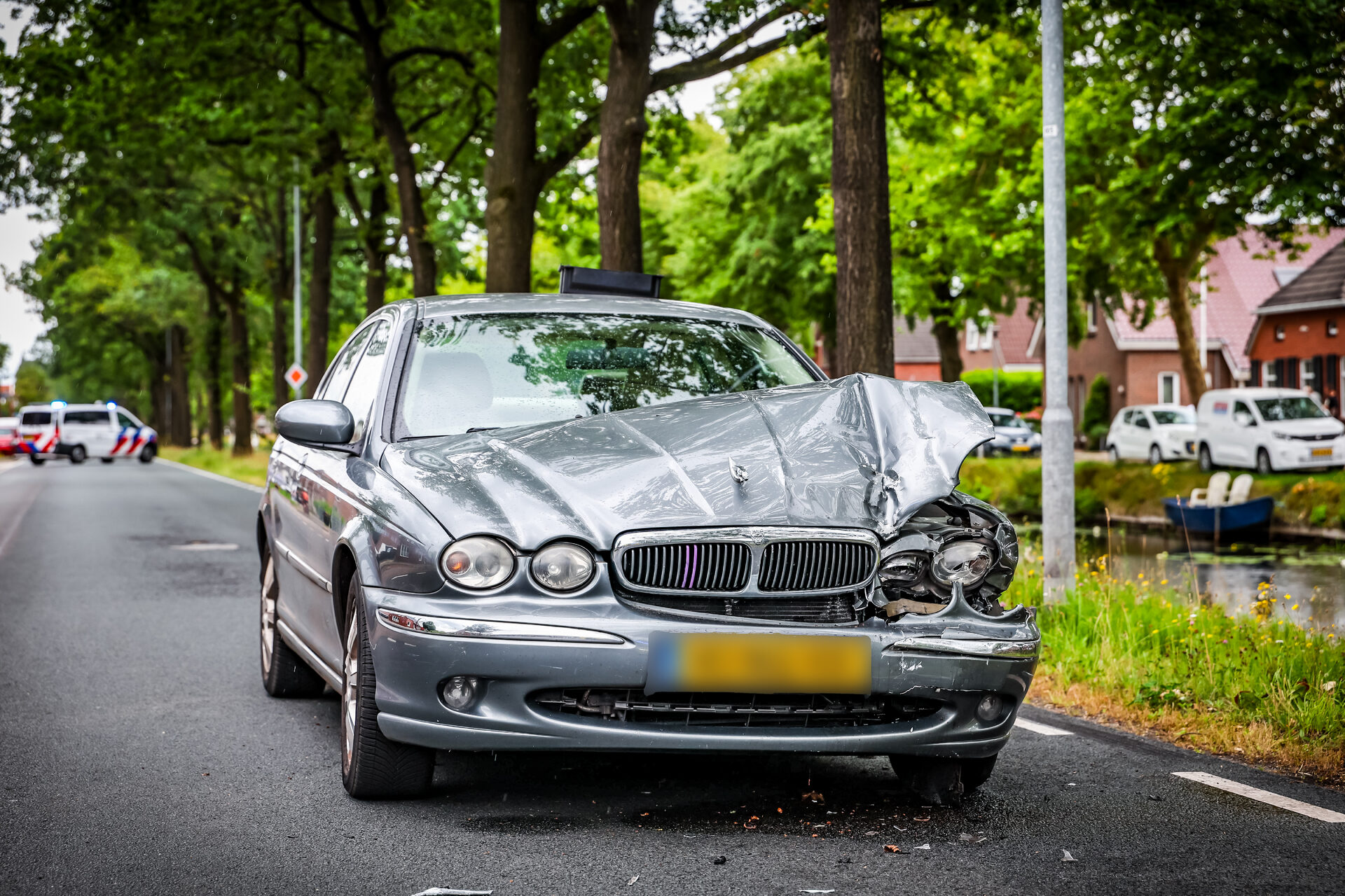 Auto te water na botsing, één persoon naar ziekenhuis