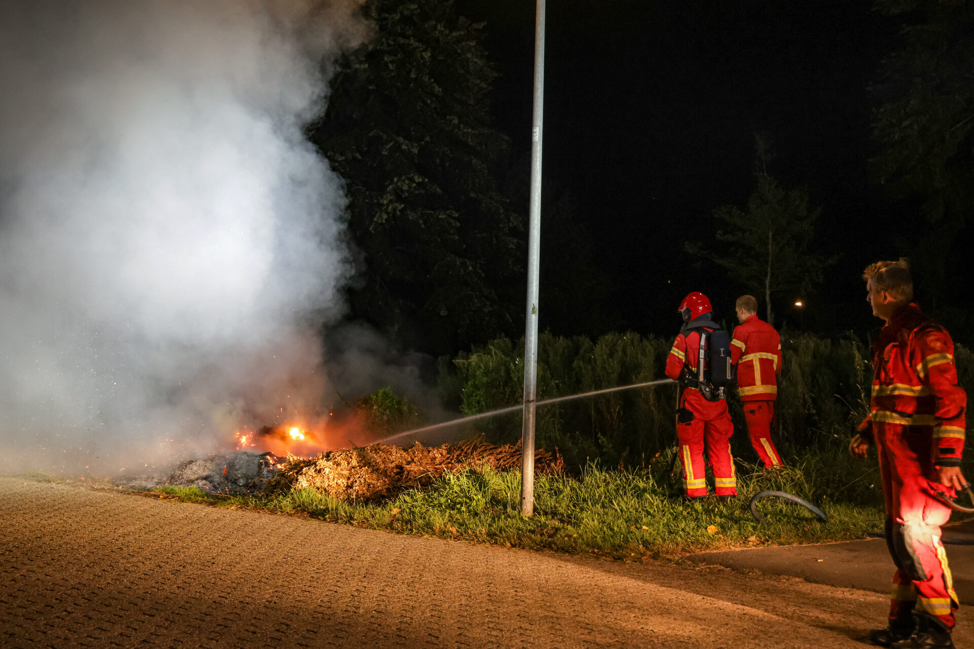 Hoop snoeiafval vliegt in brand langs de weg