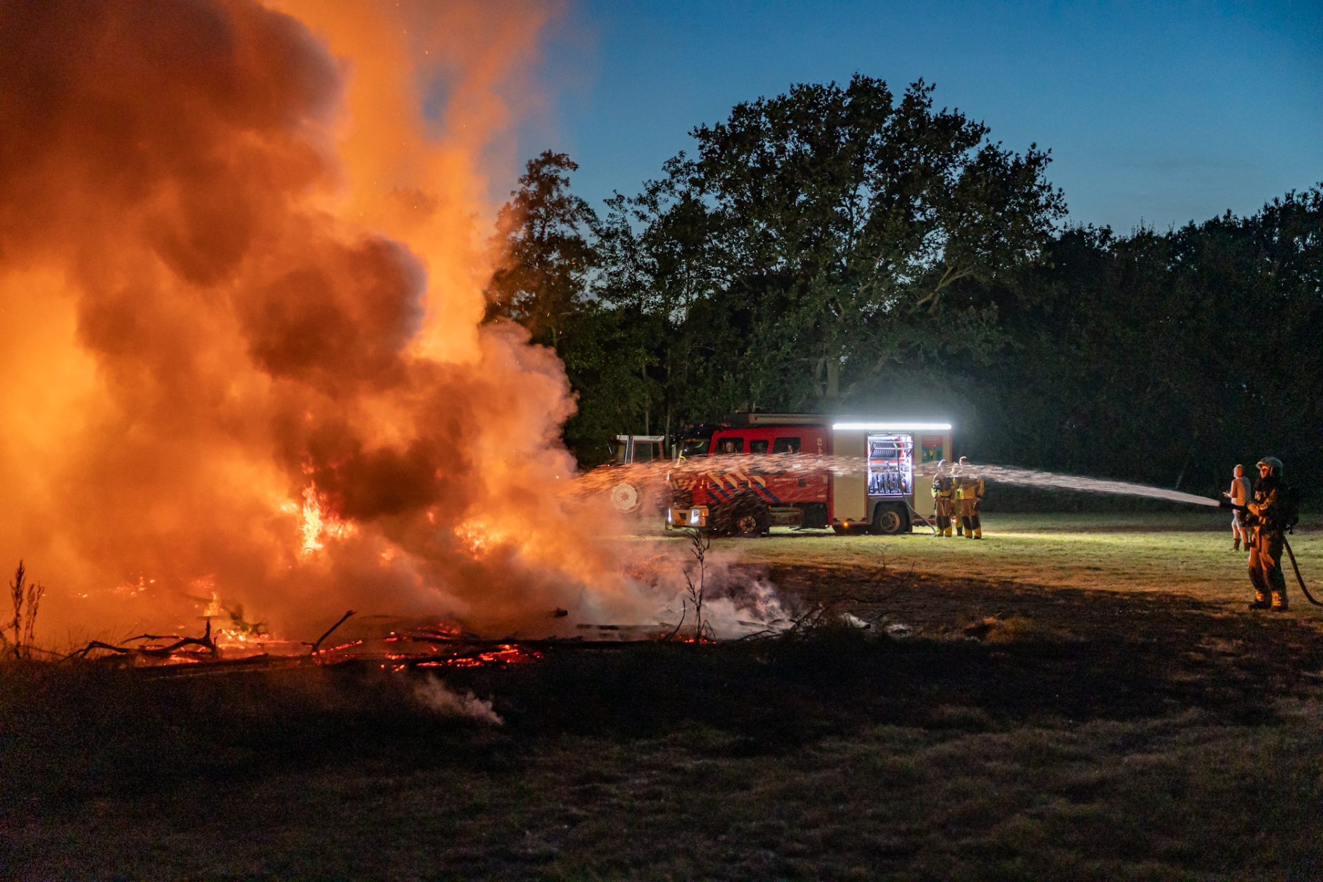 Meterhoge vlammen door brandende berg met takken