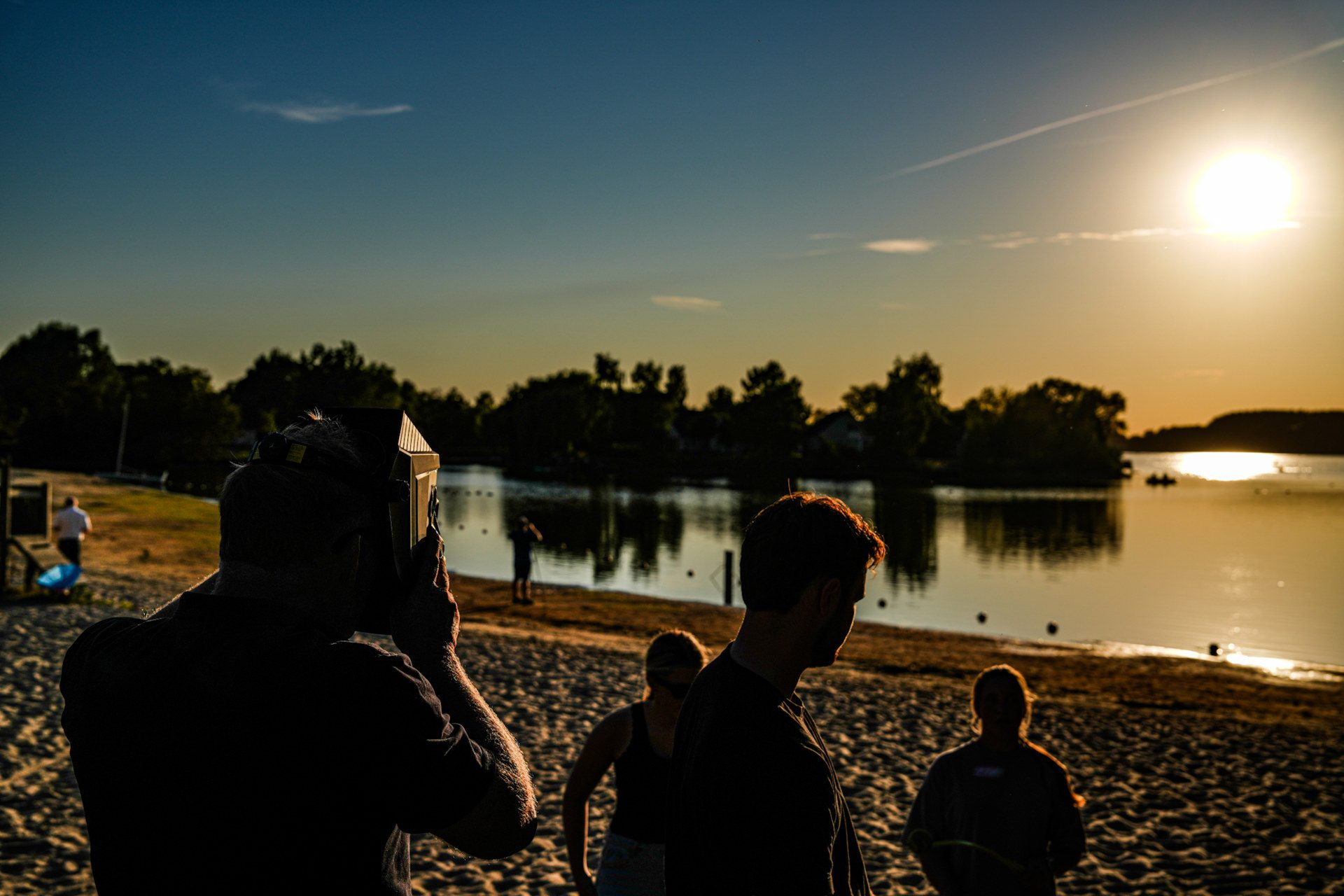 Tientallen mensen verzamelen zich voor spectaculaire zonsverduistering boven het water