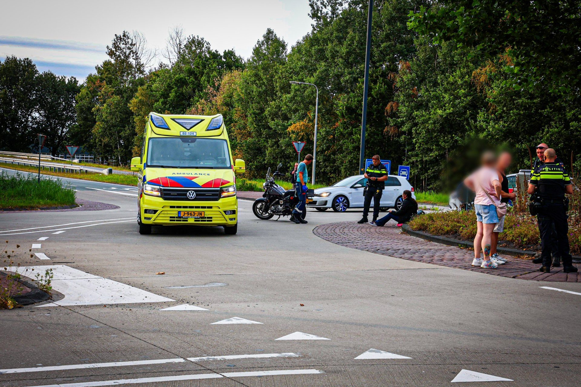 Motor en auto botsen op rotonde