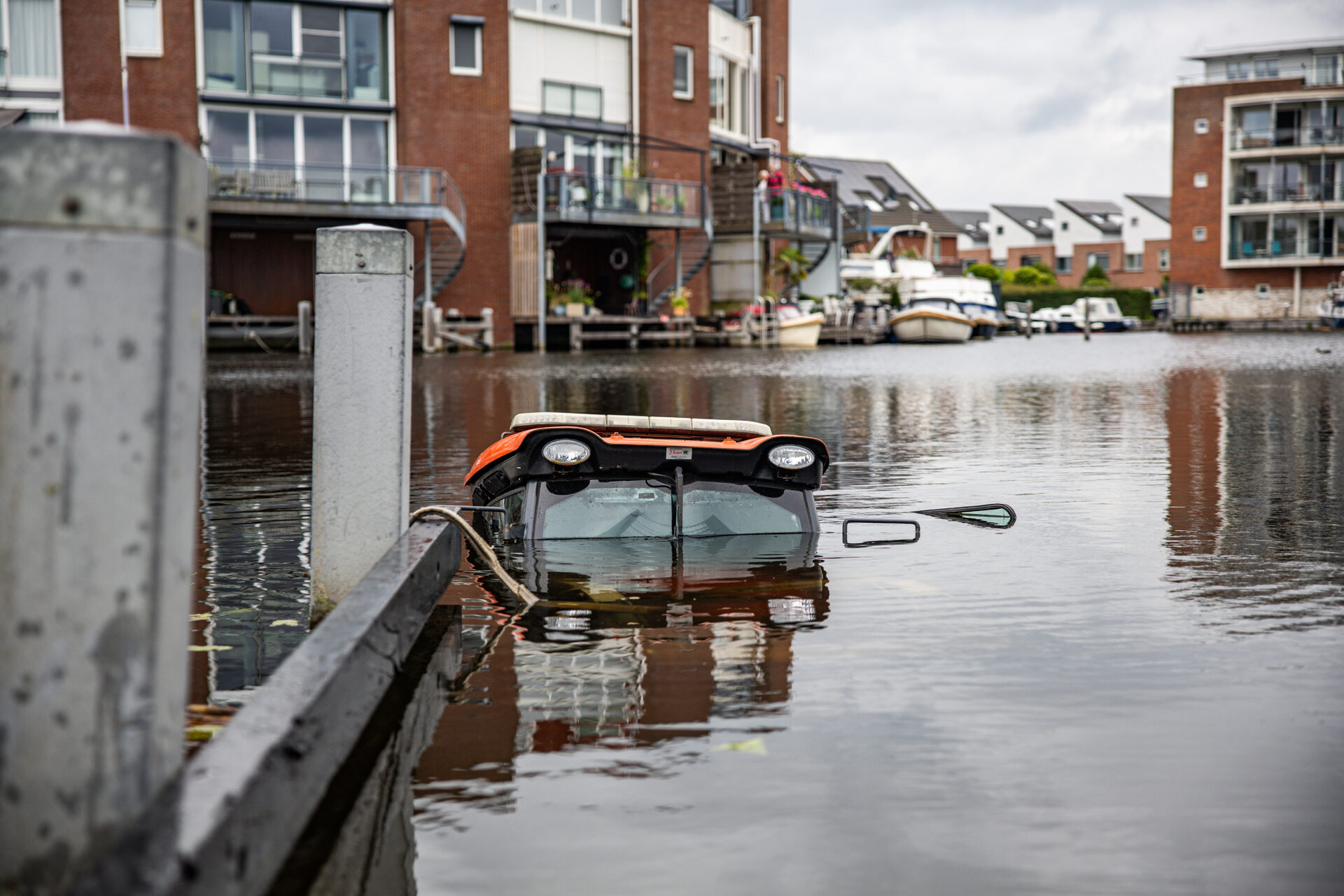 Trekker met trailer rolt achteruit en belandt in water