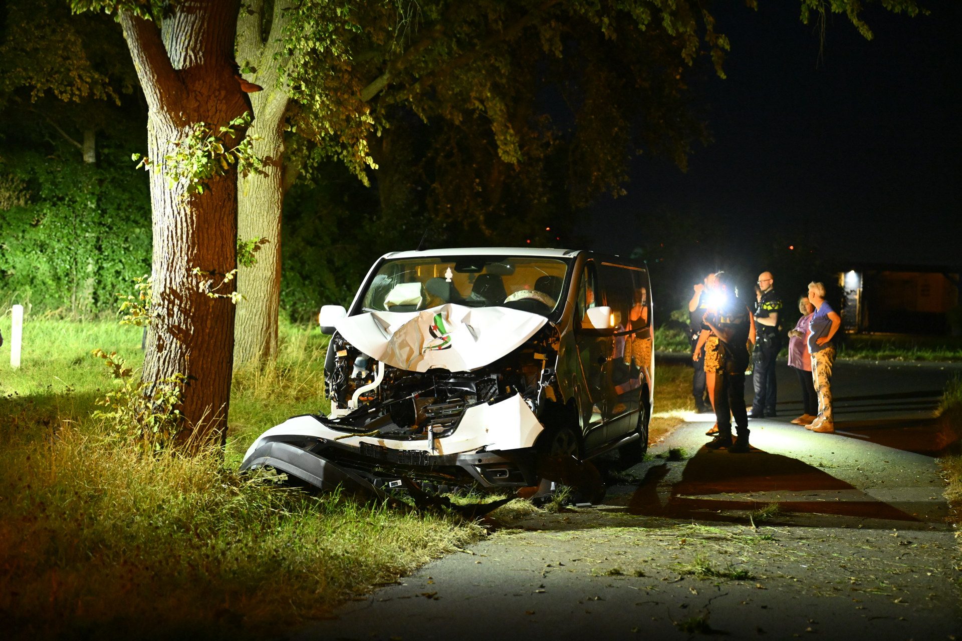 Bestelbus knalt op boom, bestuurder door omwonenden bevrijd