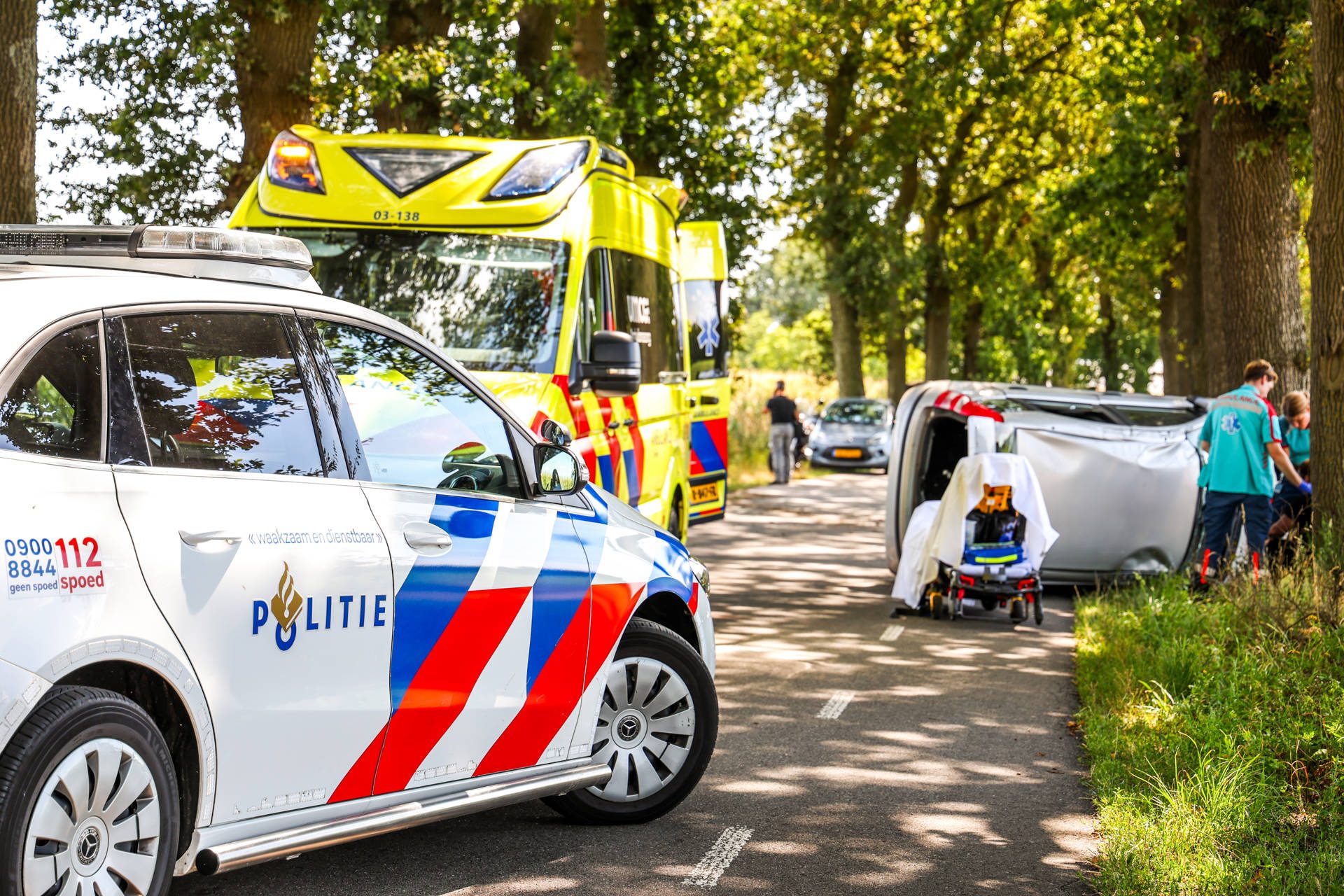 Auto op zijkant na botsing tegen boom