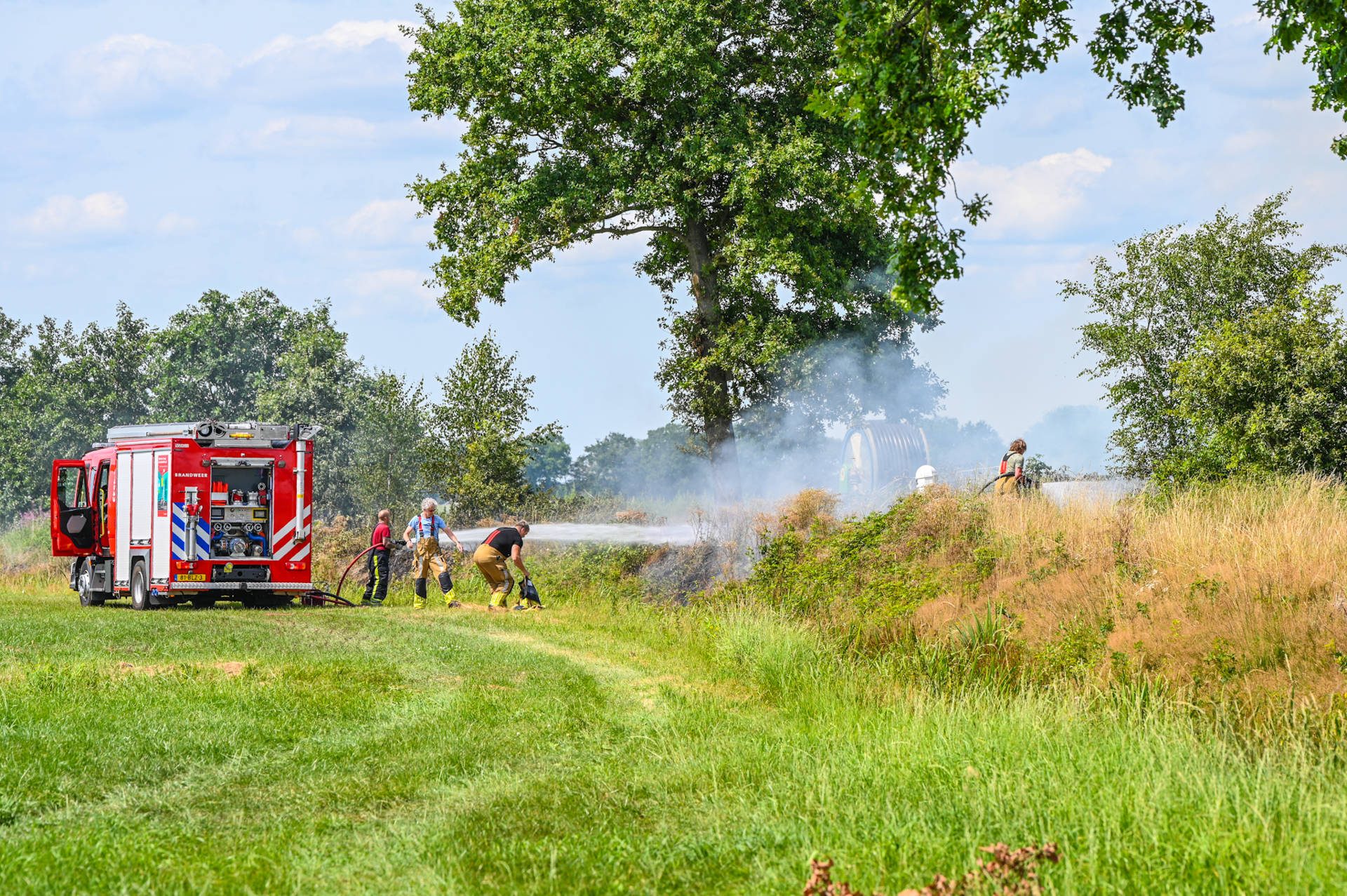 Brandweer bestrijdt forse bermbrand