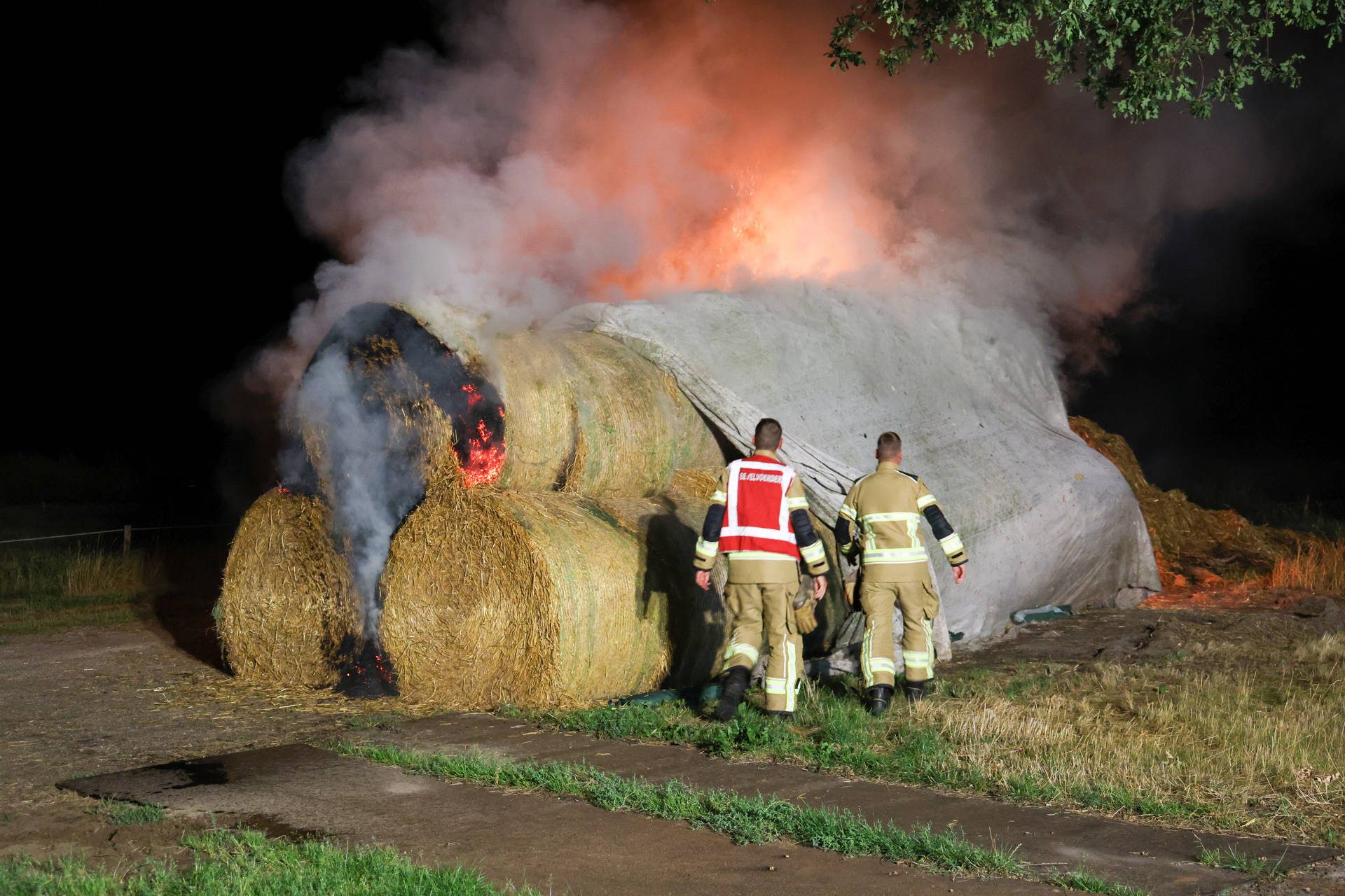 Grote stapel met strobalen in brand