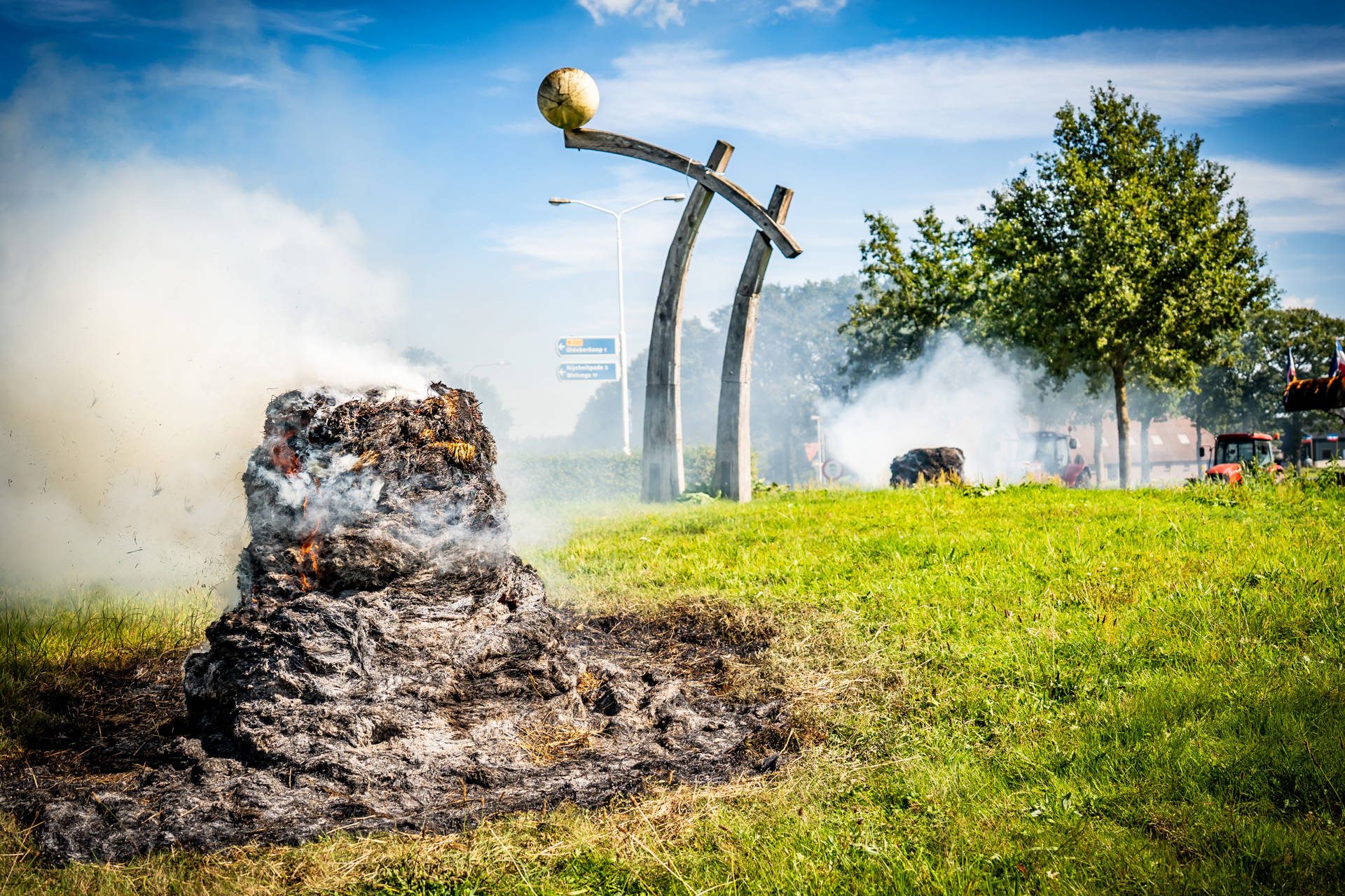 Boeren verzamelen zich met trekkers, hooibalen in brand