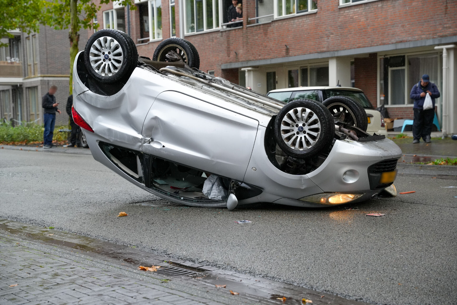 Auto belandt op dak na botsing met geparkeerde auto