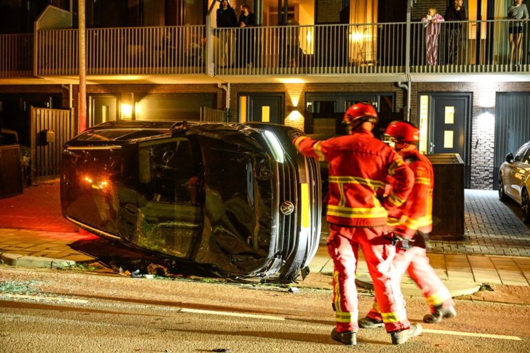 Auto belandt op zijkant na botsing tegen geparkeerde auto’s