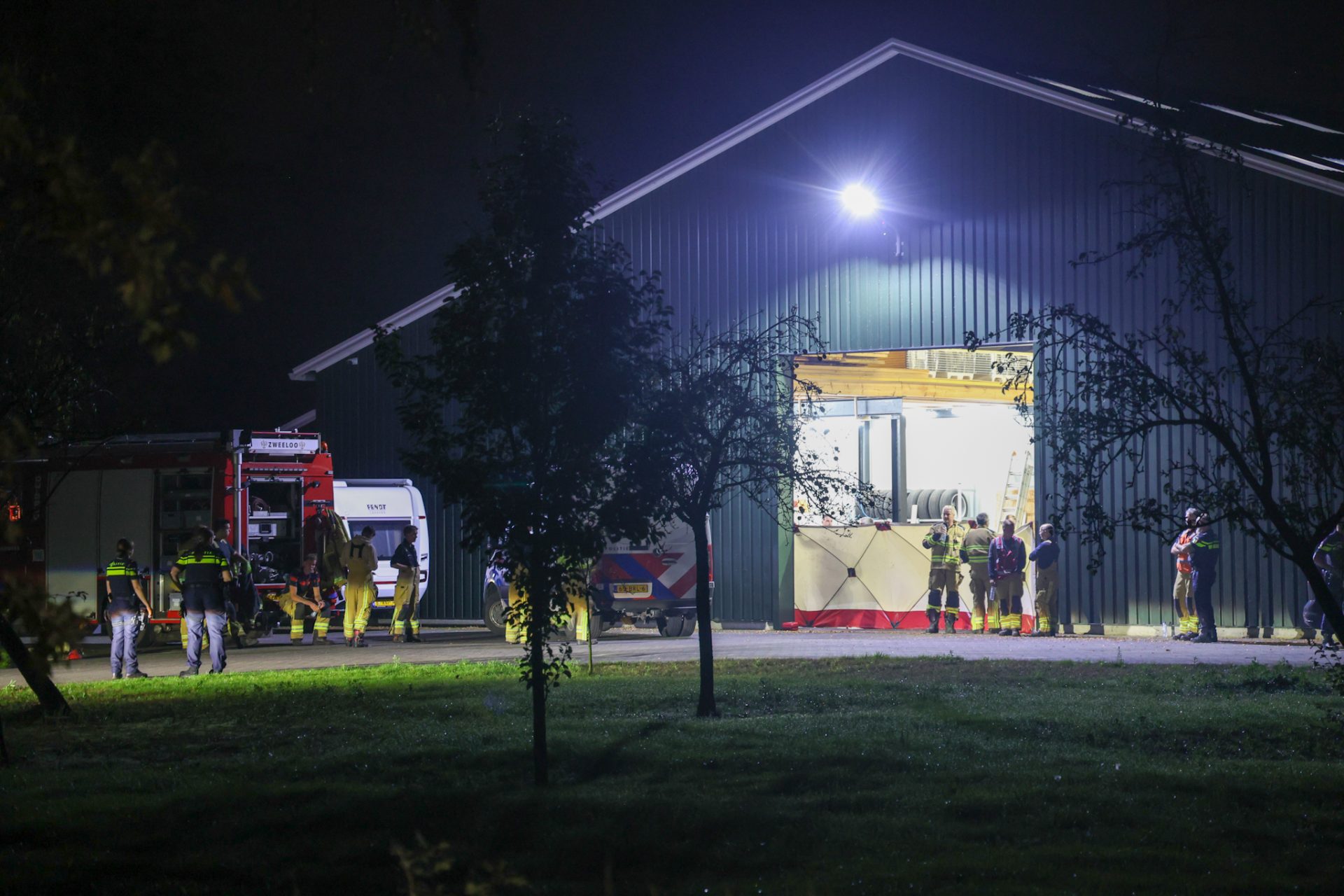 Persoon bekneld onder vrachtwagen in grote schuur