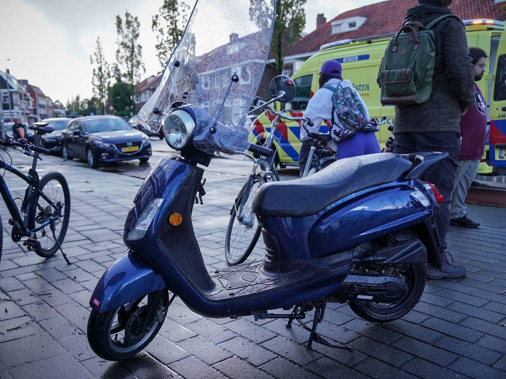 Scooter glijdt uit op glad wegdek, bestuurder naar het ziekenhuis