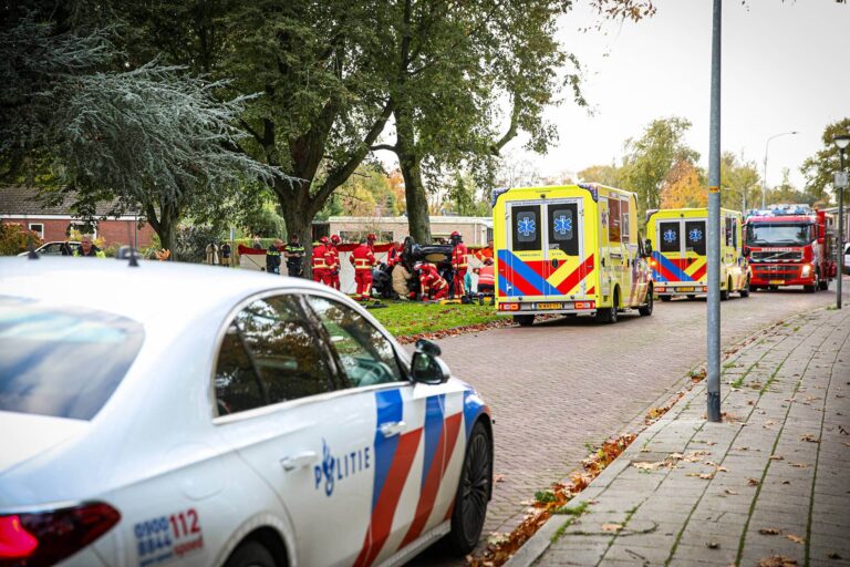 Auto slaat over de kop na botsing tegen boom