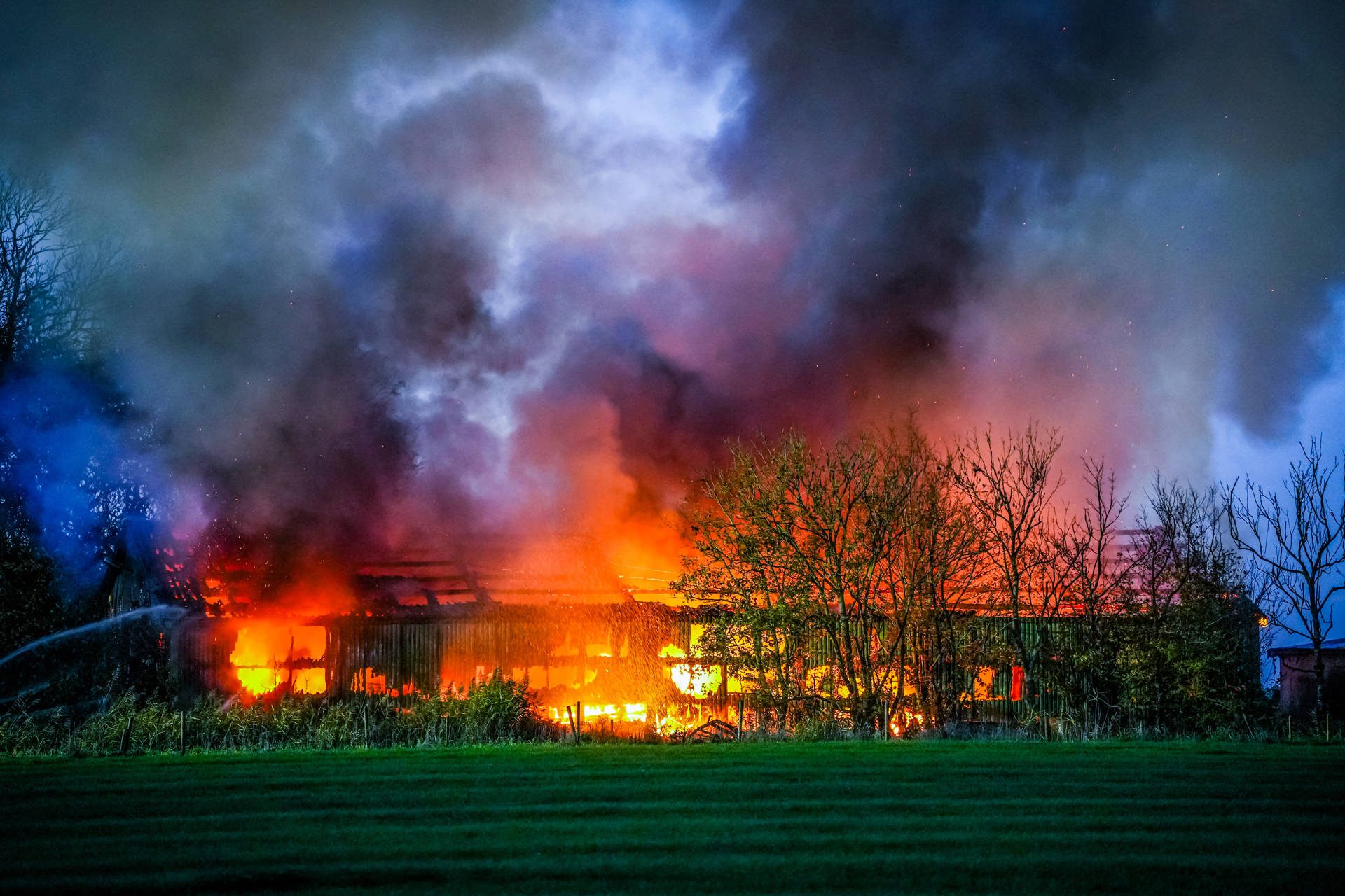 Flinke rookwolken bij grote uitslaande brand in een schuur
